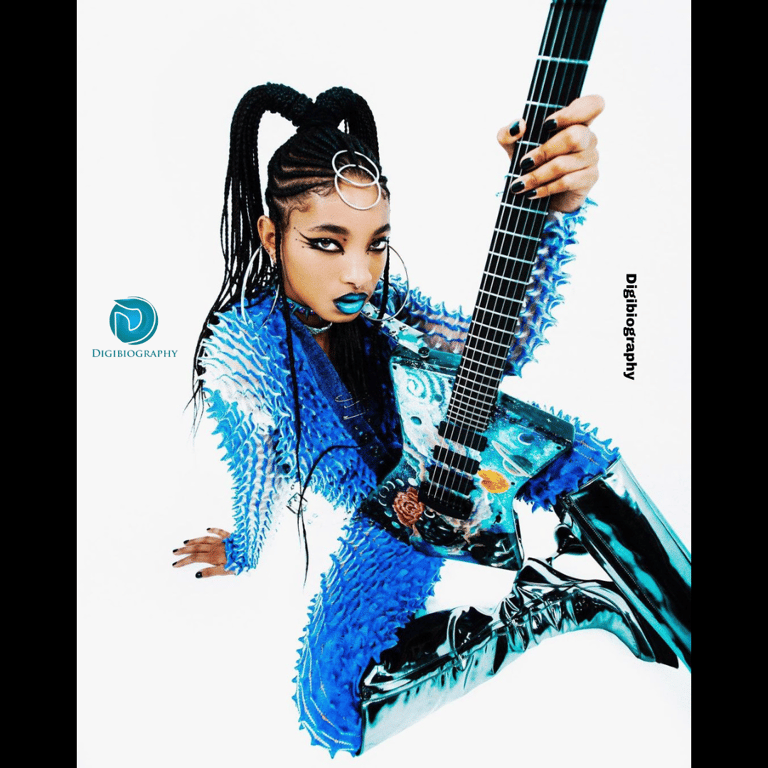 Willow Smith wearing a blue dress while holding a guitar in his hand