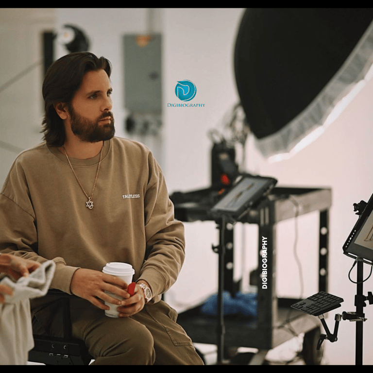 Scott Disick wearing a brown full slive t-shirt and sitting in the studio