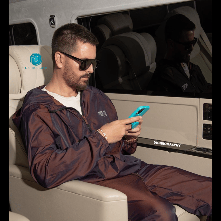 Scott Disick sitting in her private jet and using her phone