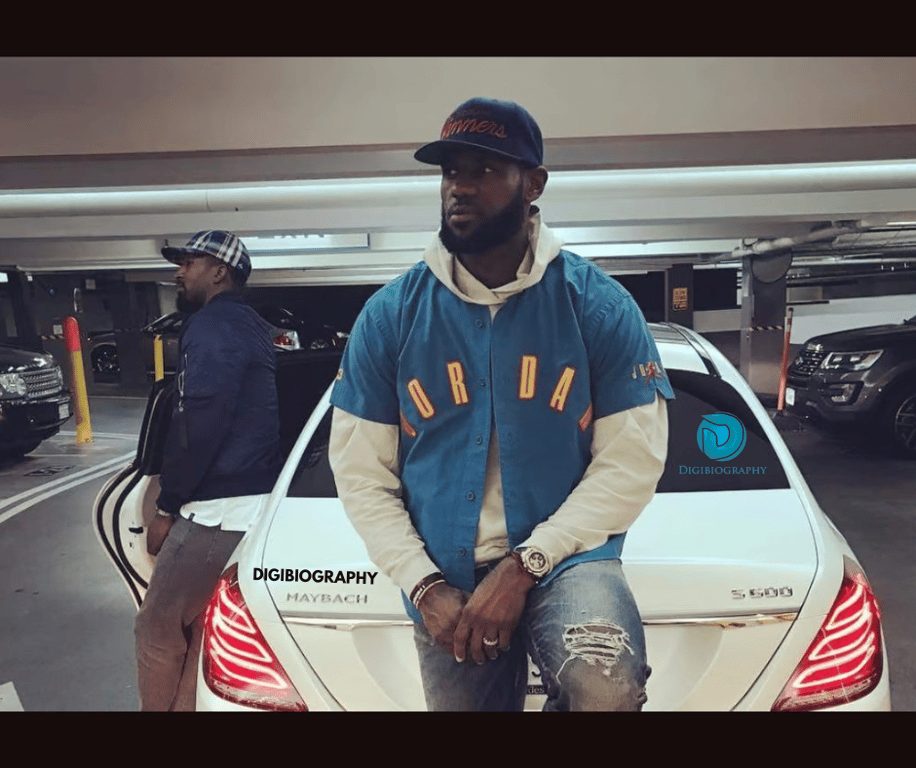 Lebron James stands next to her car and wears a blue jacket
