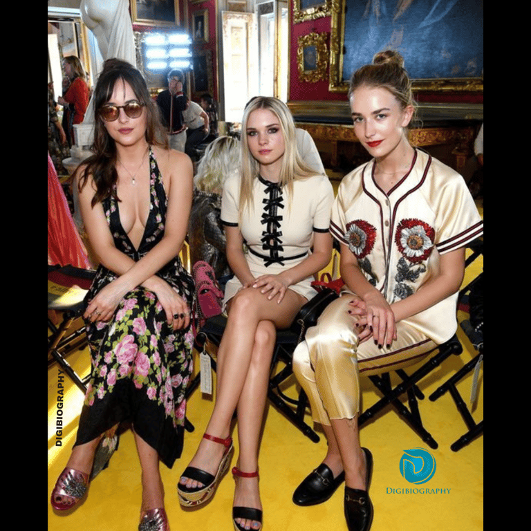 Dakota Johnson sitting with her sister and wearing black-flower dress