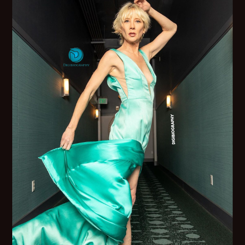Anne Heche wearing a green dress and gives a pose for a photo