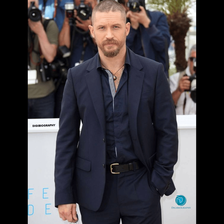 Tom Hardy wearing a blue coat and attending an award faction