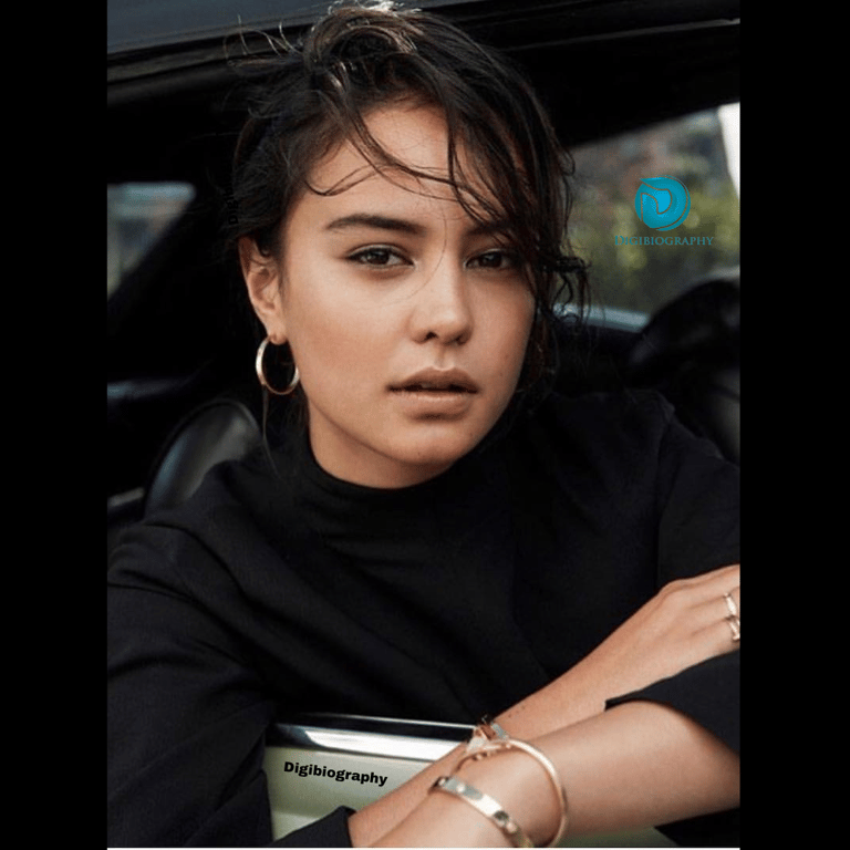 Courtney Eaton wearing a black t-shirt and sits in the car
