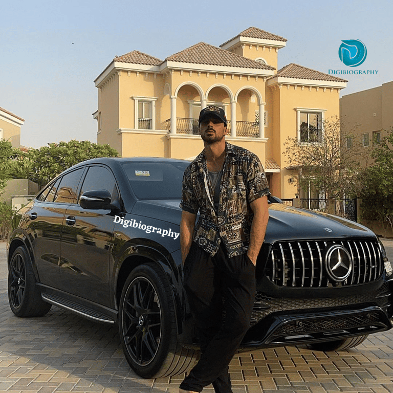 Michele Morrone stands in front of his black Mercedes car out of their house