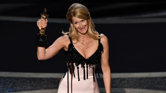  Laura Dern stands on the stage by showing the award in his hand