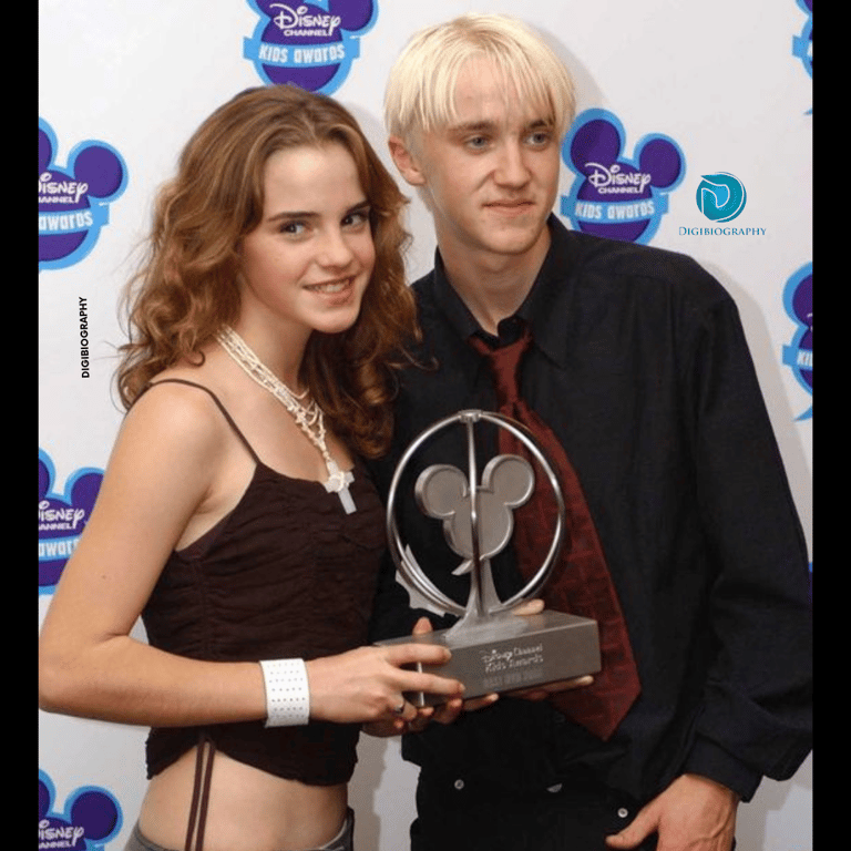 Emma Watson stands with Tom Felton and takes her Disney award