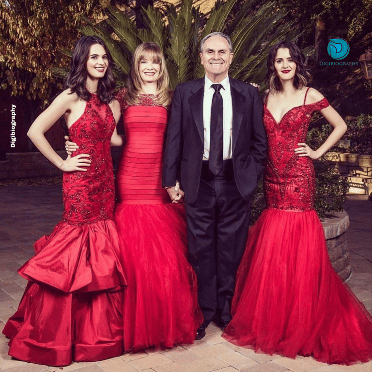 Vanessa Marano wearing a red dress while standing with the family