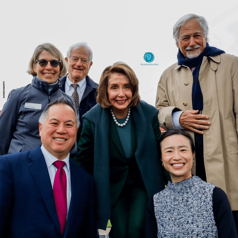 Nancy Pelosi stands with her party member and wearing a black blazer