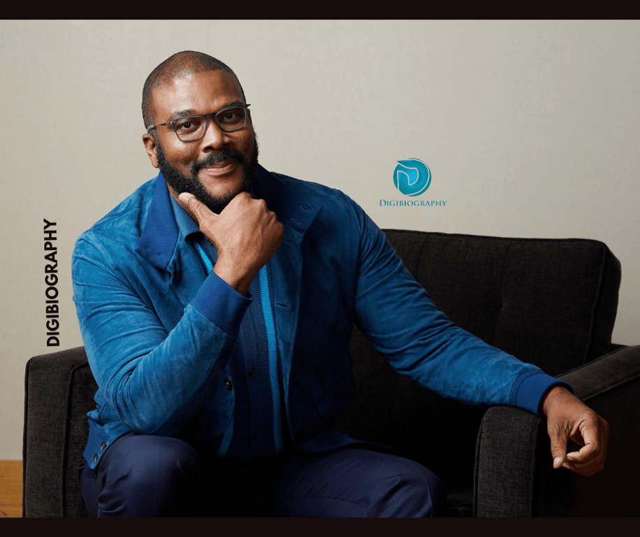Tyler Perry wearing a blue jacket and sitting on the sofa