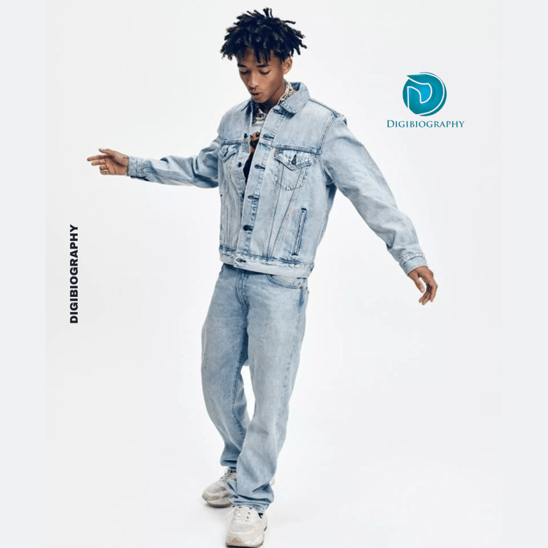 Jaden Smith stands on the hall while wearing blue jeans and jecket