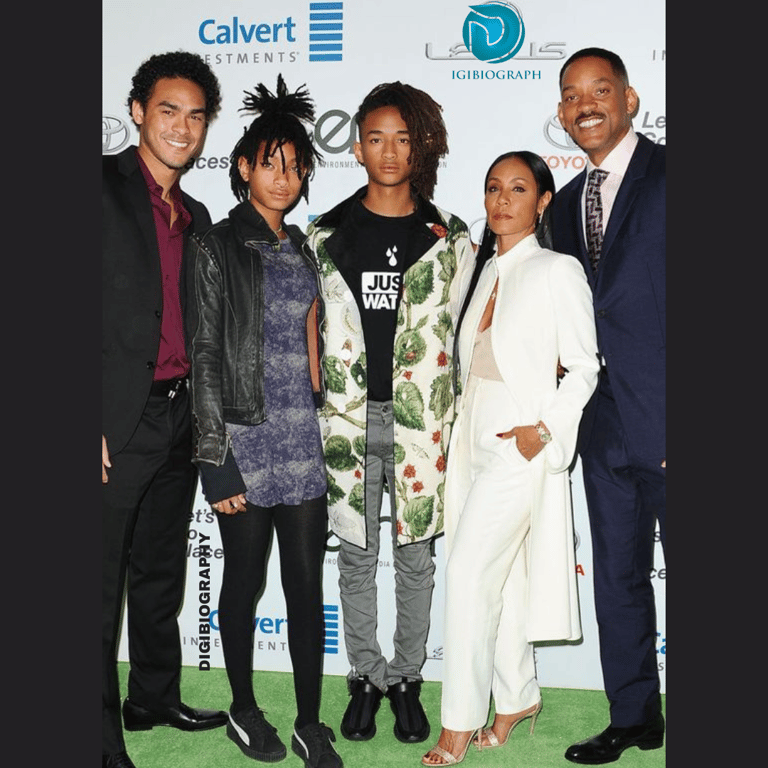 Jaden Smith standing with her family and wearing a white- flower jacket and black t-shirt
