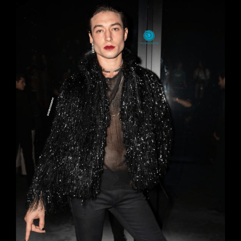 Ezra Miller gives a pose for a photo while wearing a black dress