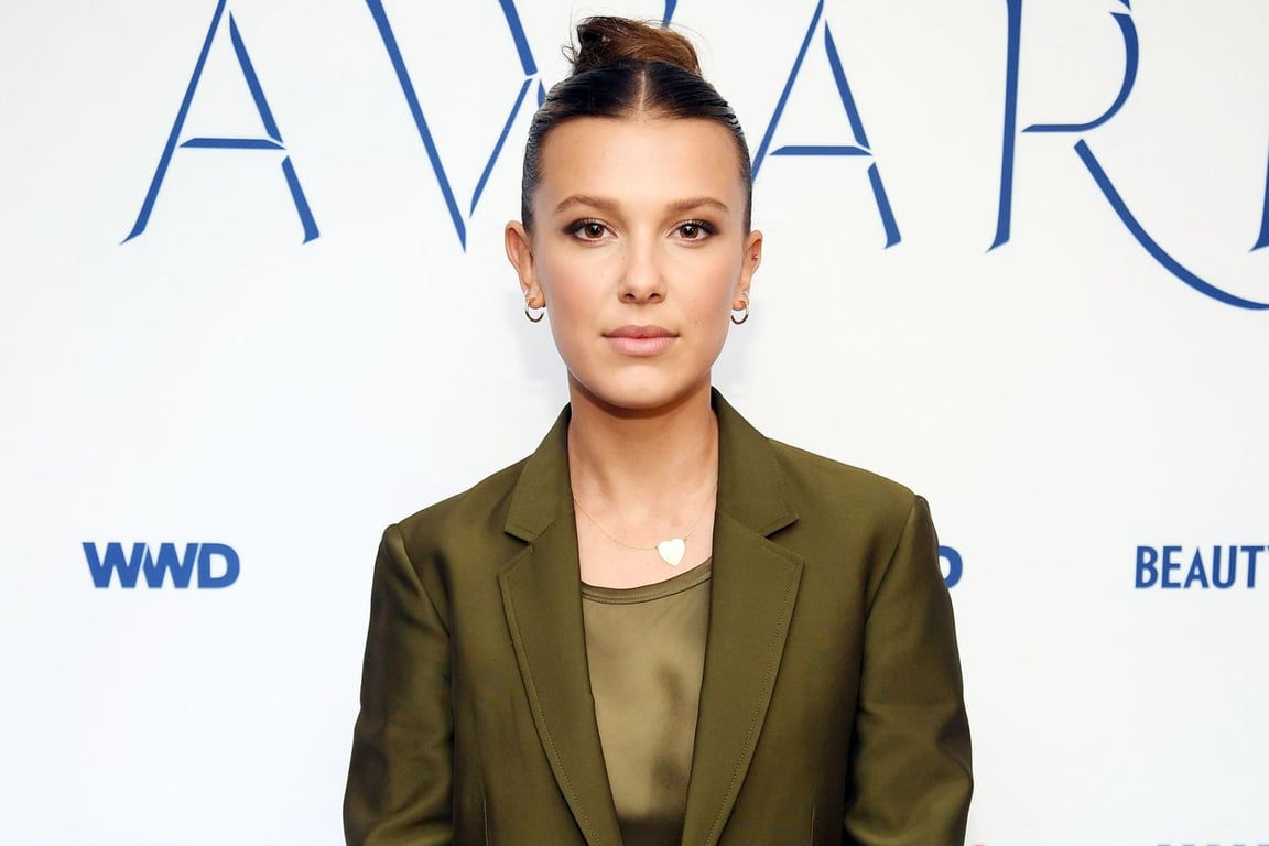 Millie Bobby Brown wearing a dark green suit in an award show