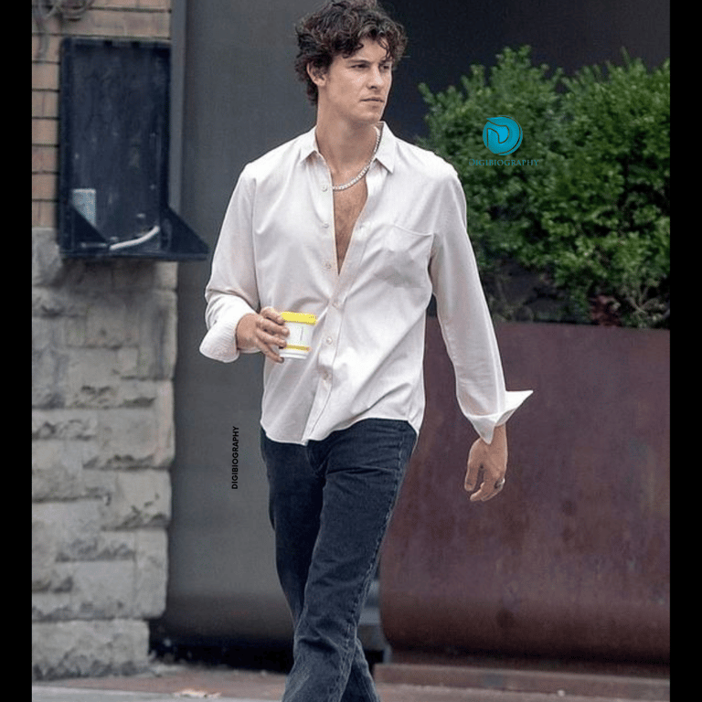 Shawn Mendes wearing a white shirt and walking on the road