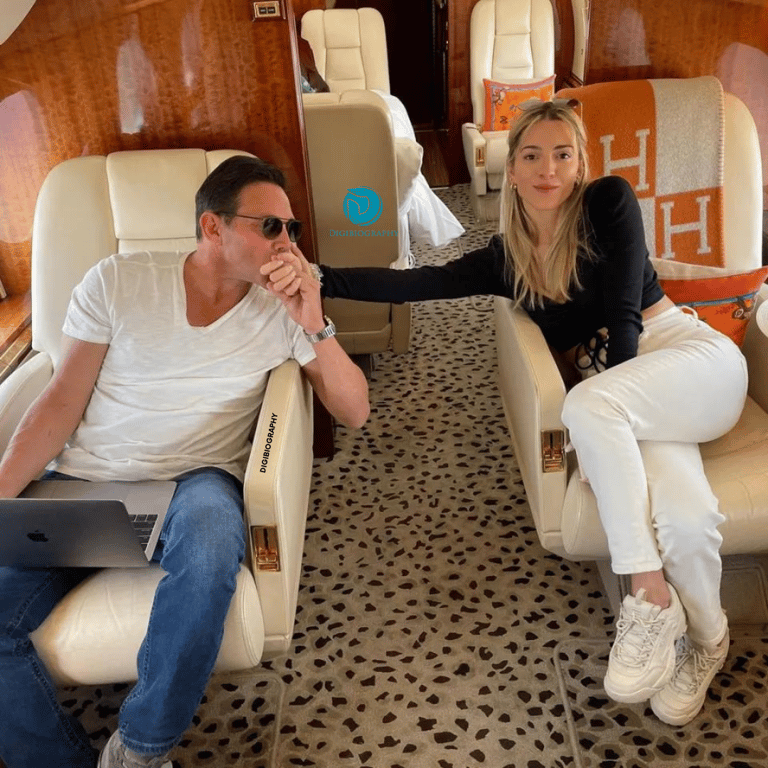 Jordan Belfort wearing a white t-shirt and sitting with her wife 