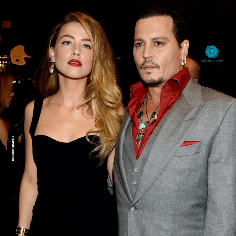 Amber Heard wearing a black dress and stands with Johnny Depp