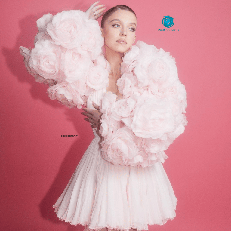 Sydney Sweeney wearing a white color dress and stand in pink background