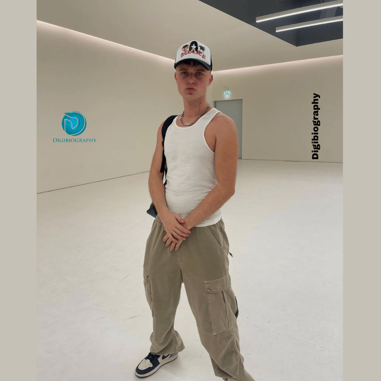 HRVY standing in the white room while wearing a white sendo with the cap