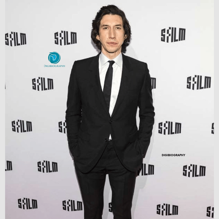 Adam Driver attends a faction while wearing a black coat and a white shirt