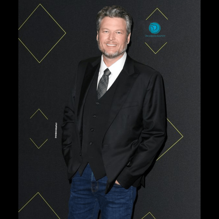 Blake Shelton wearing a black coat and gives a smile