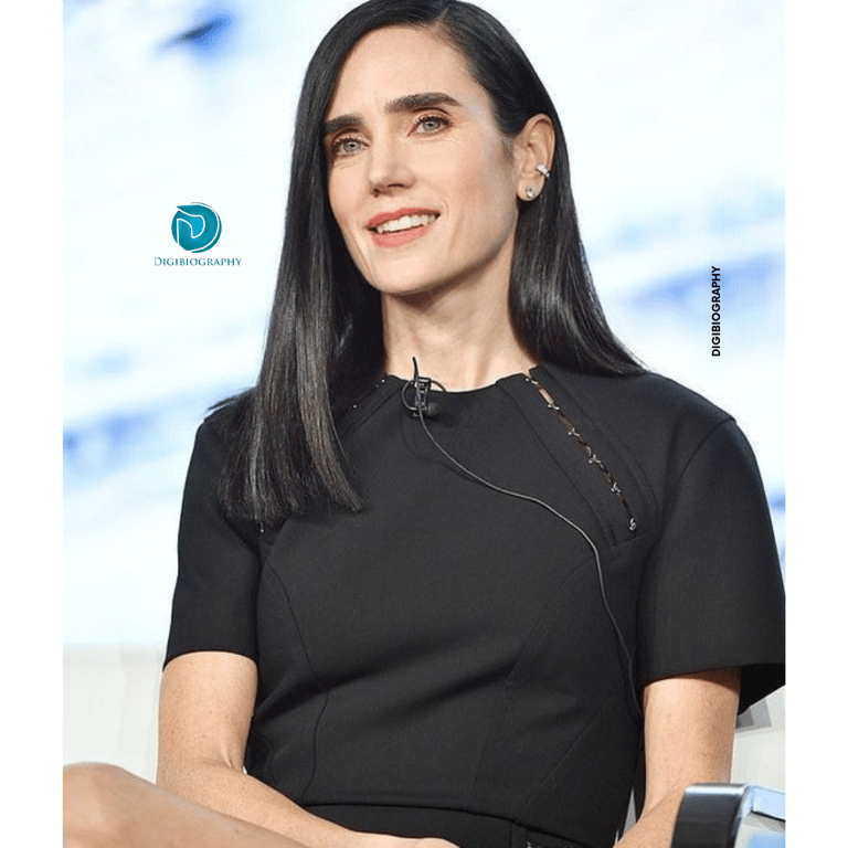 Jennifer Connelly sitting on the show while wearing a black t-shirt 