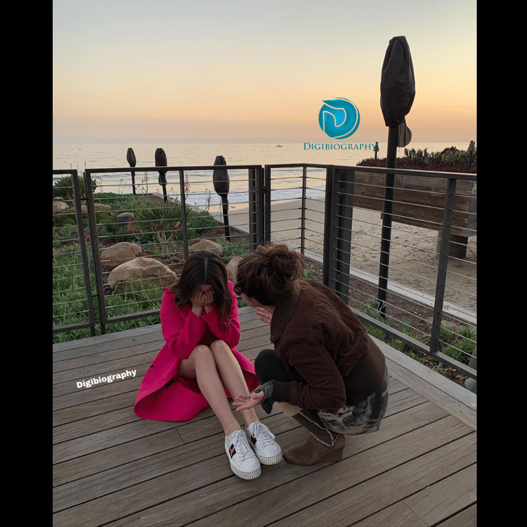 Vanessa Marano sitting on the floor in the pink dress on the terrace with the sea view