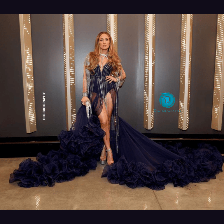 Jennifer Lopez stands on the floor while wearing a blue dress