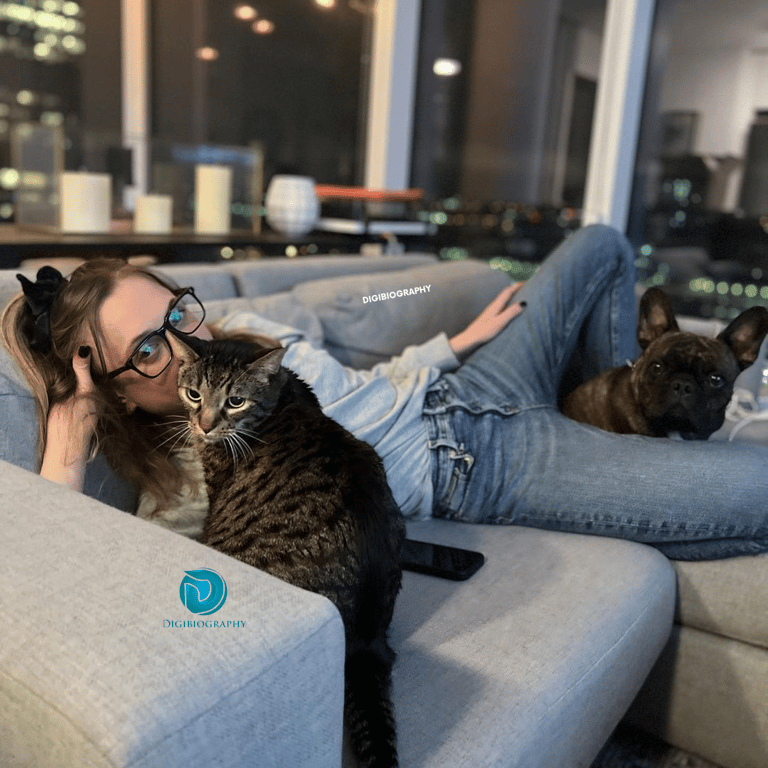 Kat Timpf sitting on the sofa with her cate