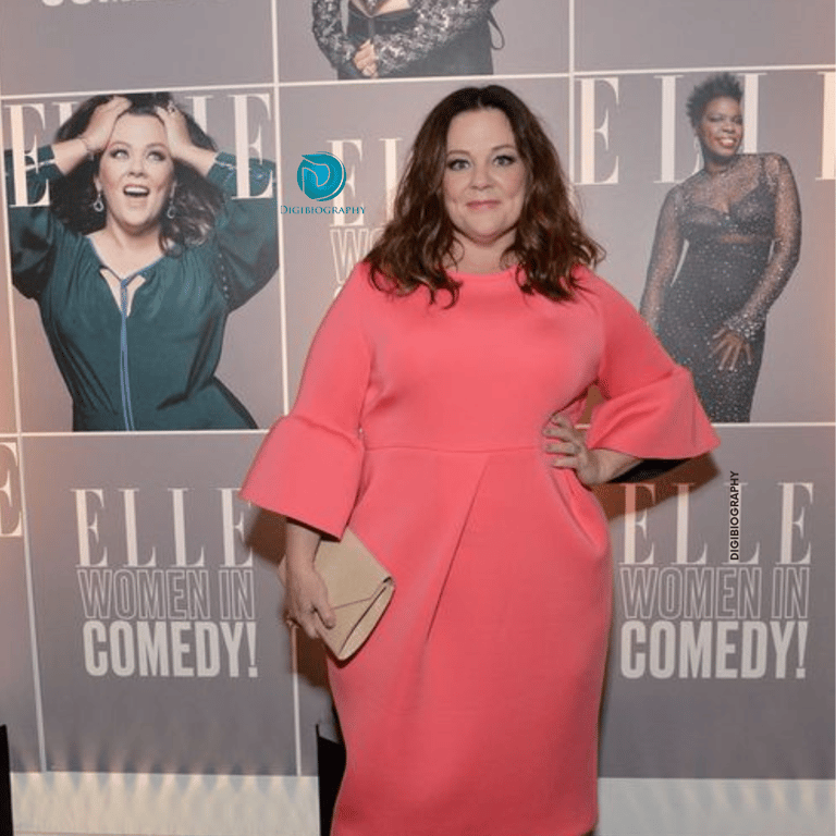 Melissa McCarthy wearing a pink dress and gives a look