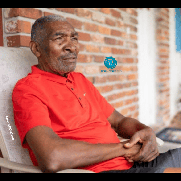 Richard Williams sitting on the chair and wears a red t-shirt