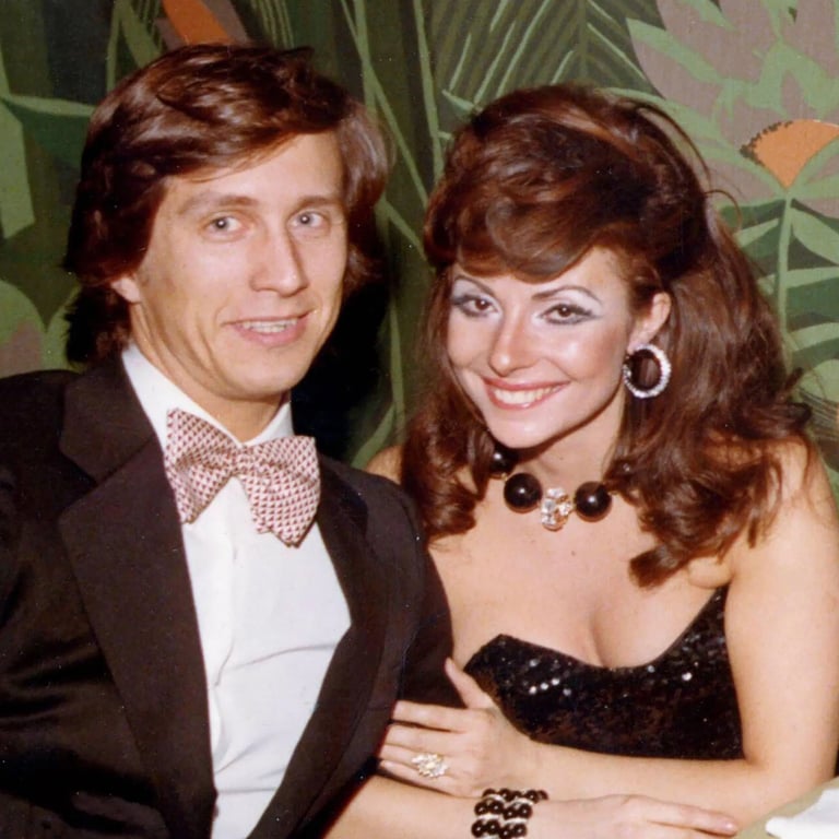 Patrizia Reggiani sitting with her husband Maurizio Gucci and wearing a black dress