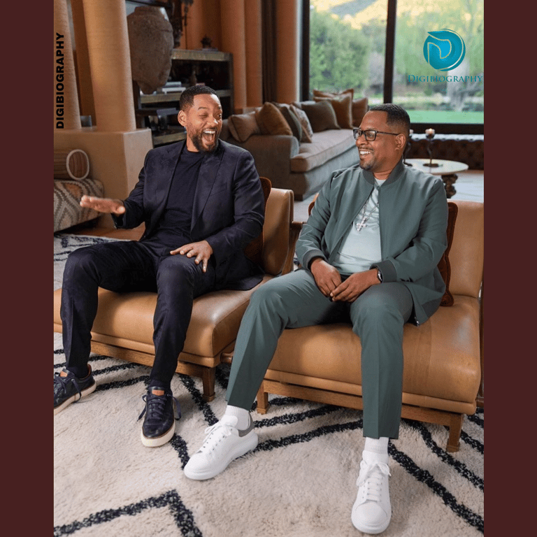 Will Smith sitting with a friend in their house while wearing a blue suit
