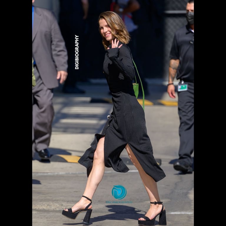 Betty Gilpin walking on the road Gilpin wears a black dress and says hi to her fan
