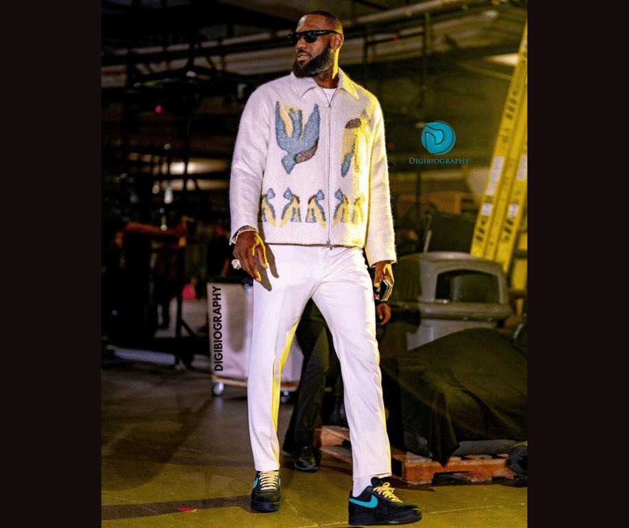 Lebron James is wearing a white jacket and gives a side look