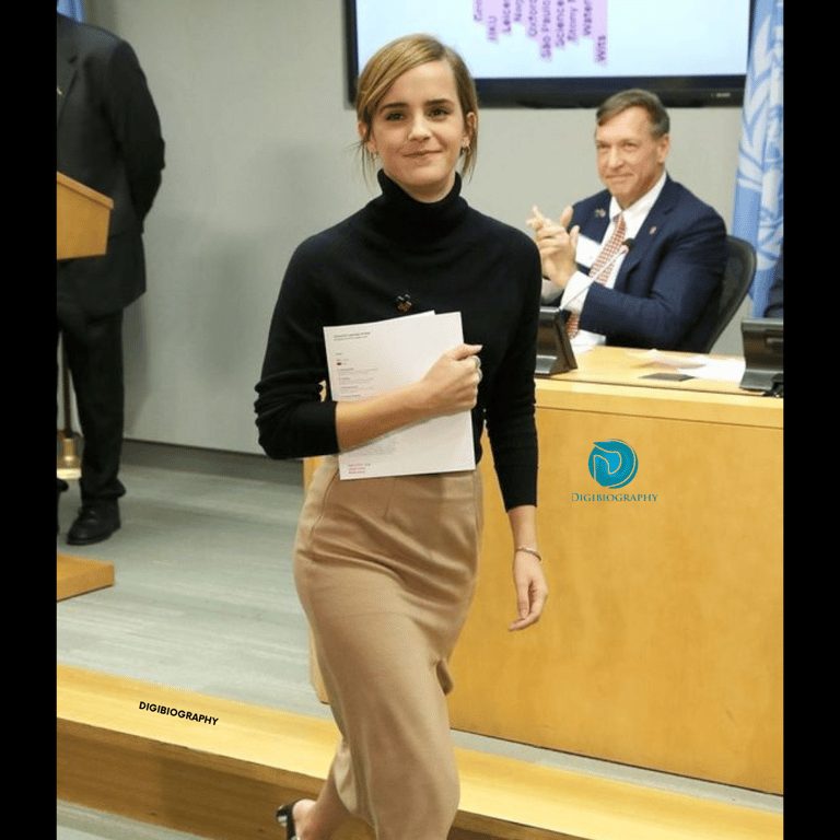 Emma Watson takes a file and walks on the floor while wearing a black and brown dress