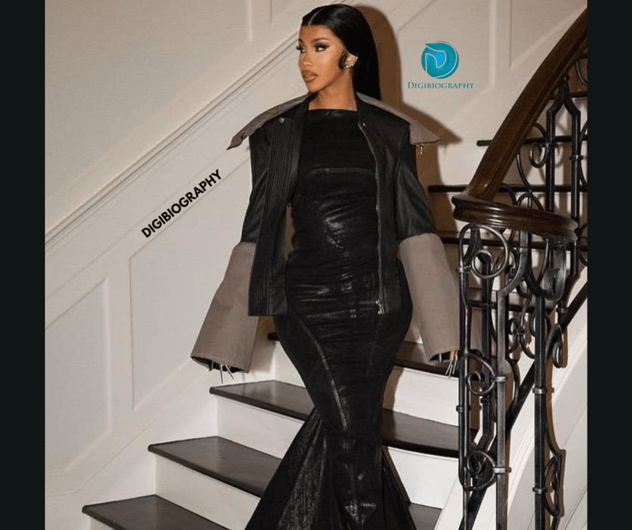 Cardi B stand on the stair and wears a black dress