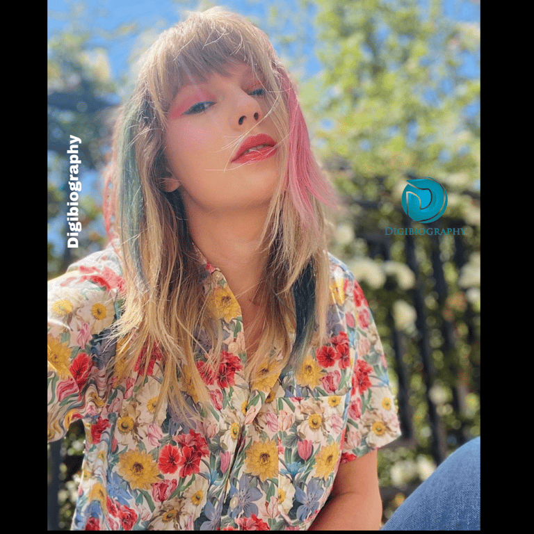 Taylor Swift sitting in the park while wearing a white flowers print shirt
