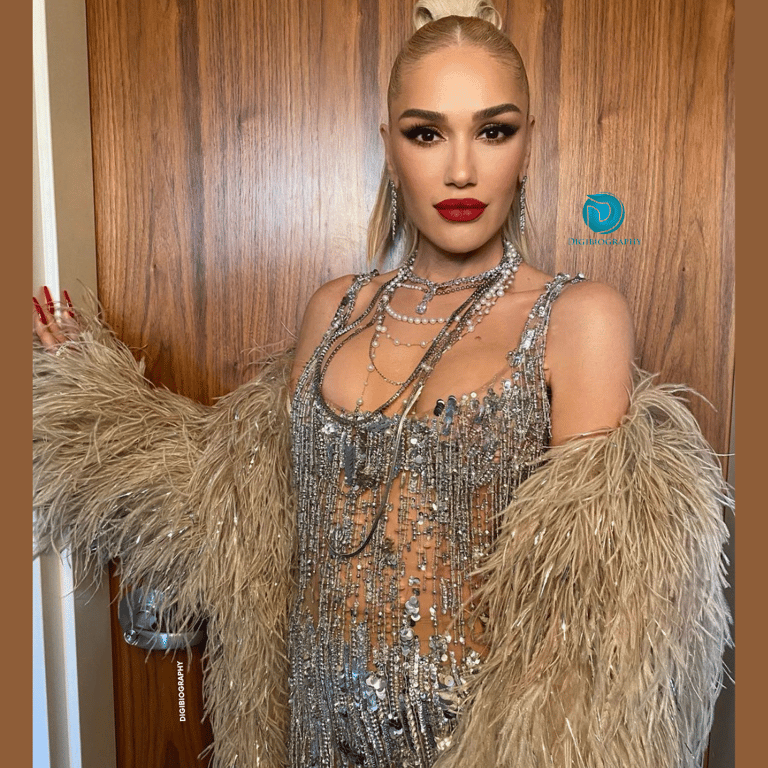 Gwen Stefani wearing a silver dress while stand close to the wall