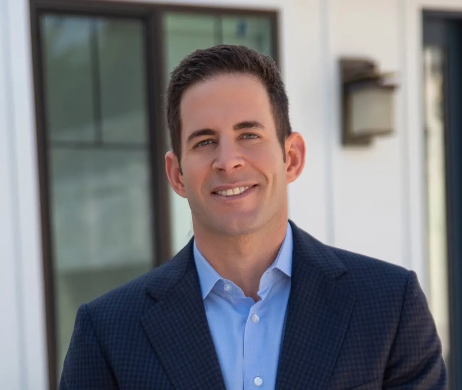Tarek El Moussa wearing a suit and standing in an open area