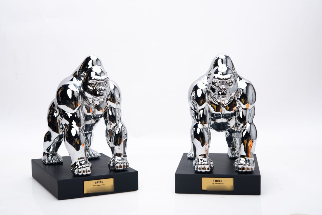 Two chrome gorilla trophies on black bases with gold TRIBE award plates
