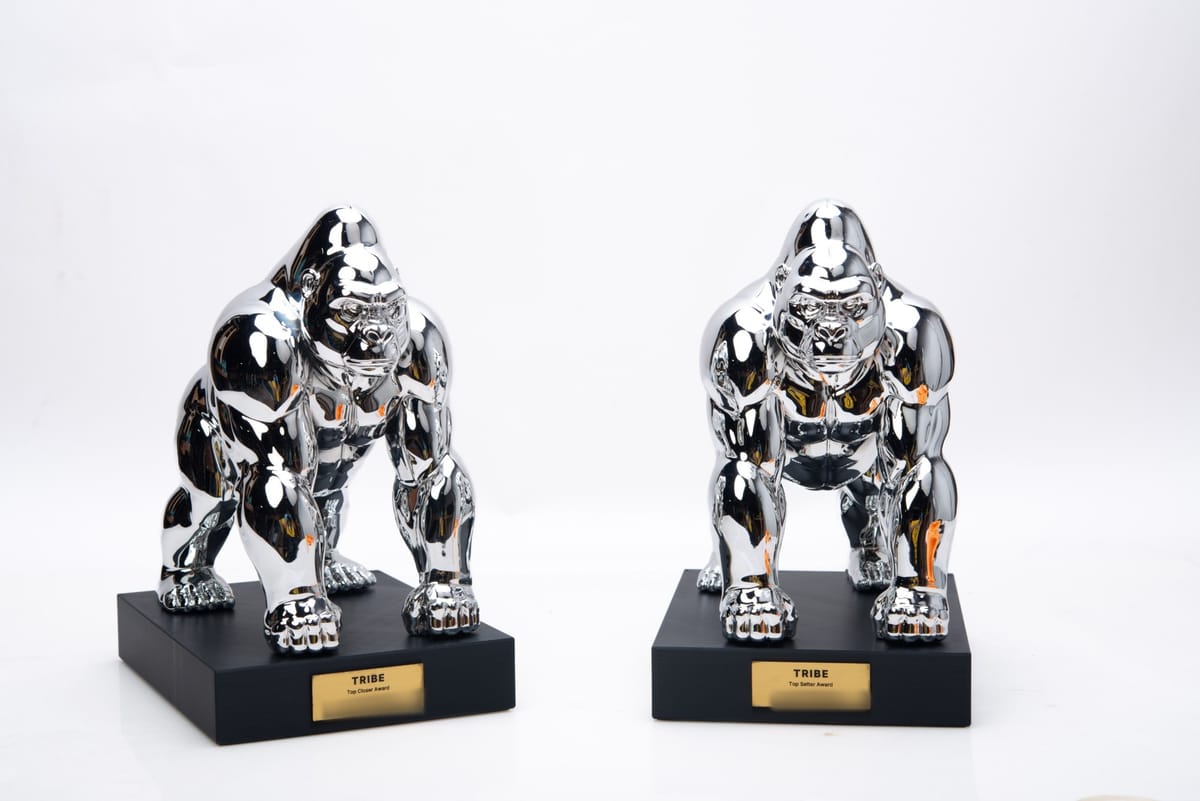 Two chrome gorilla trophies on black bases with gold TRIBE award plates