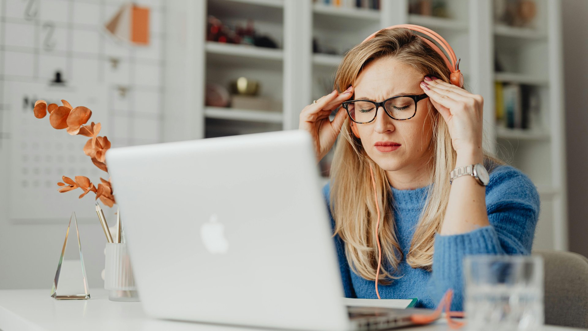 Woman with a headache sitting in front of a computer