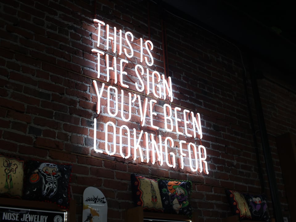 Sign with the words 'this is the sign you've been looking for' lightend up in neon
