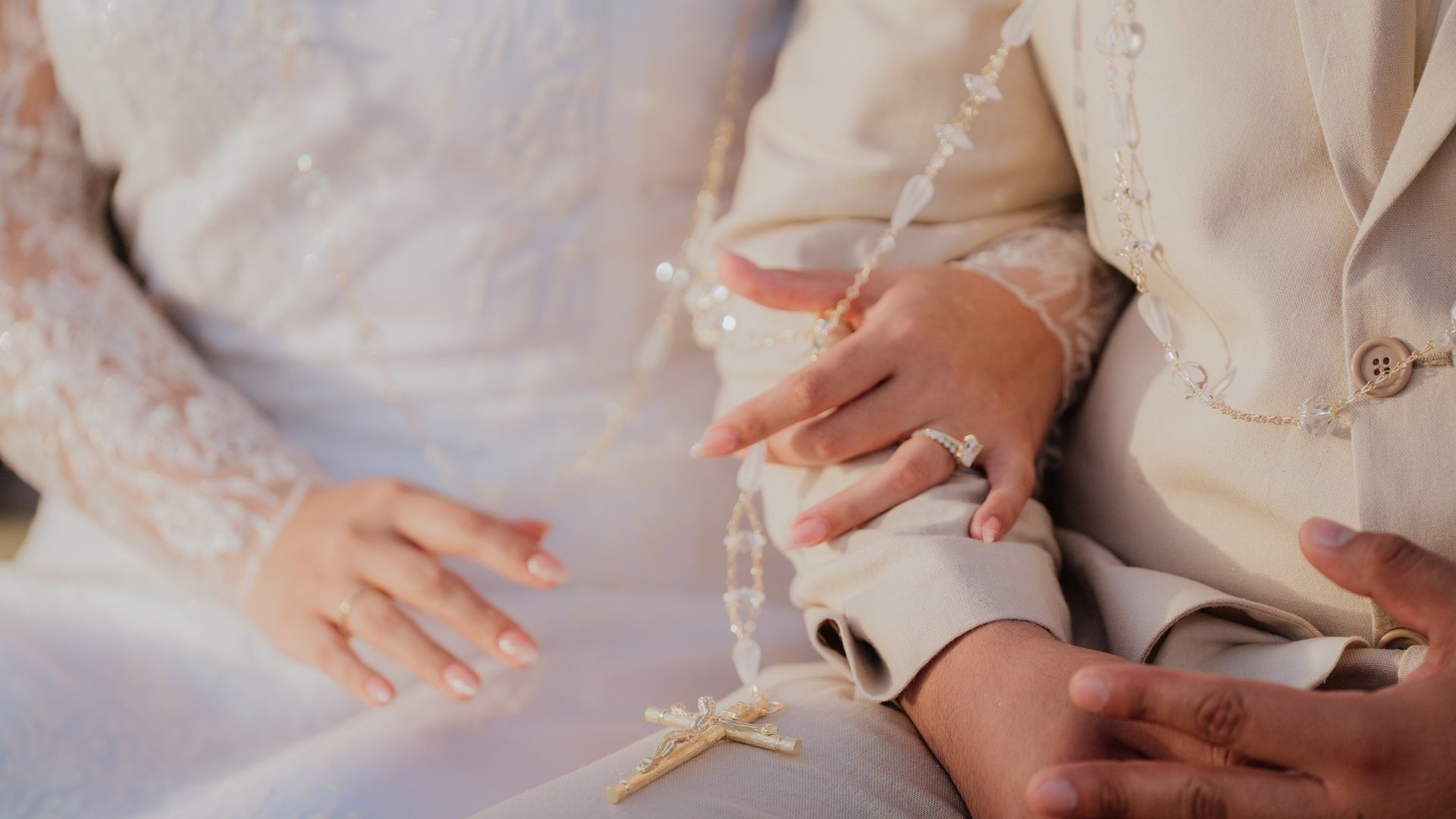 Detalle de ceremonia religiosa con lazo de perlas y crucifijo durante boda en playa