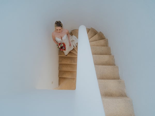 Vista aérea de escalera de villa con paredes blancas y piso de cantera en venue de bodas