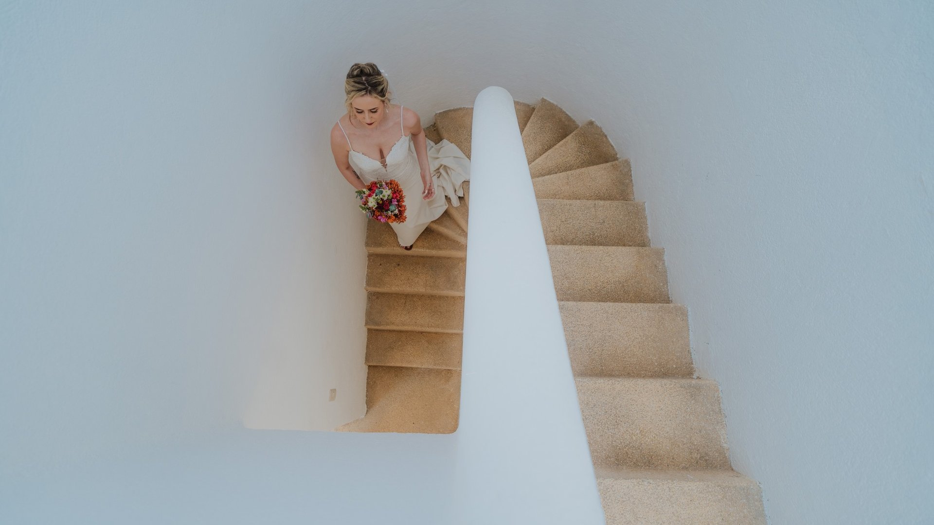 Vista aérea de escalera de villa con paredes blancas y piso de cantera en venue de bodas