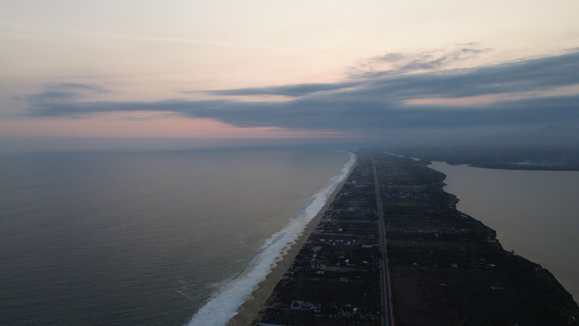 Vista aérea al amanecer de la franja costera de Pie de la Cuesta entre el Pacífico y la laguna