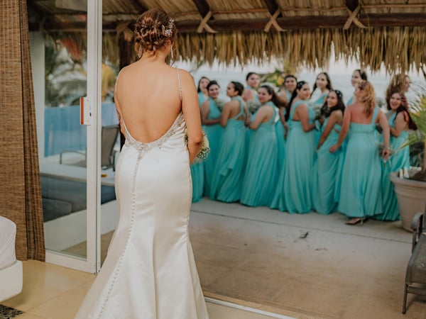 Momento previo a ceremonia bajo palapa con damas de honor en vestidos turquesa