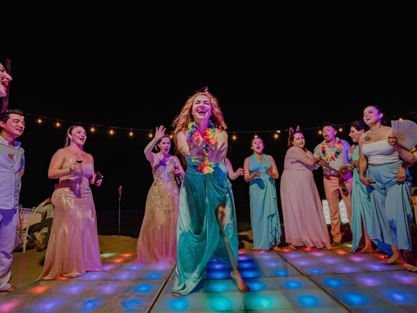 Fiesta nocturna de boda en pista iluminada con luces de colores y guirnaldas colgantes